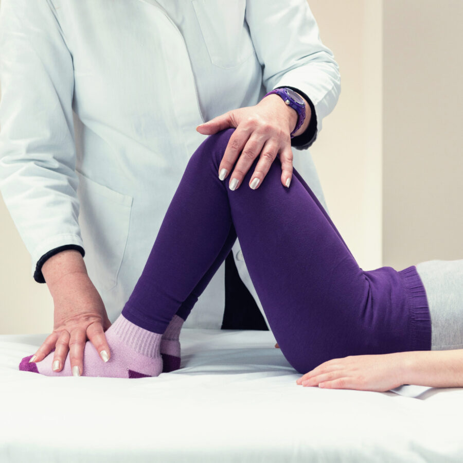 Physical therapist working with little girl on therapy bed